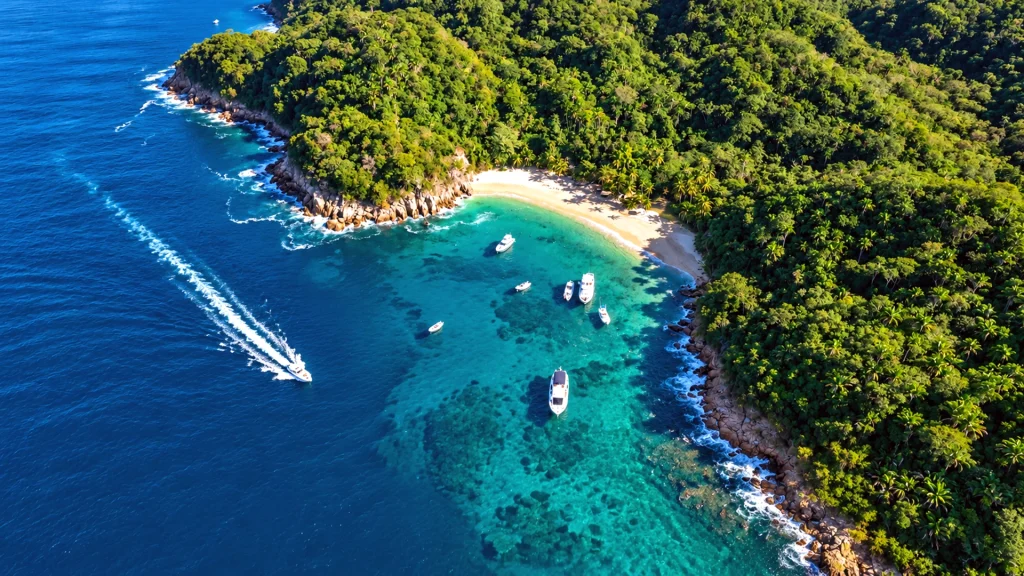 Aerial view of Majahuitas Beach near Puerto Vallarta with turquoise water, tropical jungle and boats in the secluded cove