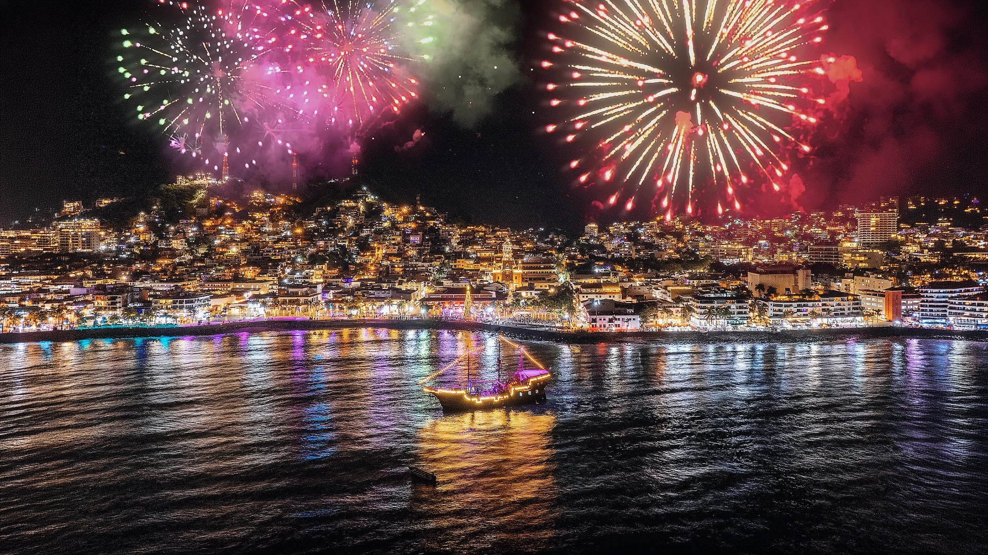 Fireworks over Puerto Vallarta with pirate ship on Banderas Bay during Pirates of the Bay night tour