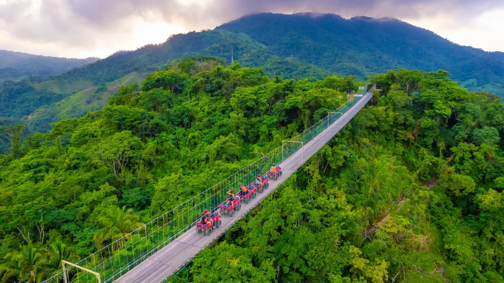 Aerial view of ATV riders crossing Jorullo Bridge in the Sierra Madre near Puerto Vallarta