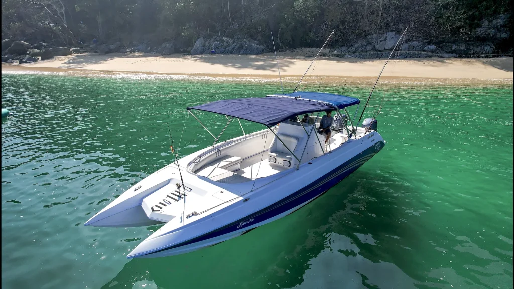 Sport fishing boat anchored beside a secluded beach in Banderas Bay